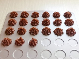 11、巧克力奶油泡芙,挤入烤盘中即可,挤手法,手不要往下压,一边挤手一边提高。(不是不粘烤盘,记得垫上油纸)