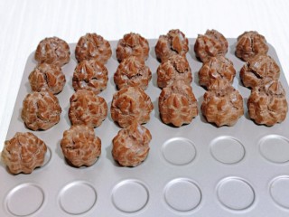 14、巧克力奶油泡芙,戴上隔热手套取出烤盘,放旁边晾凉。