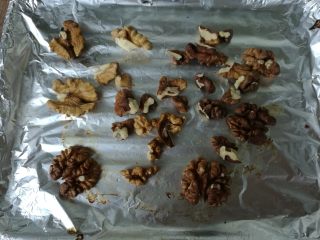 2、植物油版核桃酥,将核桃仁平铺在烤盘内,160度上下火烘烤5分钟。