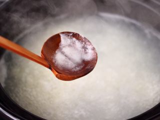 7、螃蟹青菜辣椒粥,用勺子撇去表面浮末。