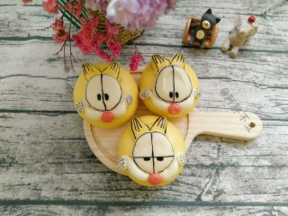 16、加菲猫花样馒头,出锅后，用可食用巧克力笔或色素笔画上表情。也可在做的时候，用可可粉面团，做好表情。