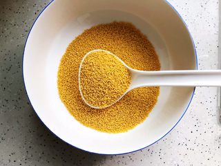 1、鸡汁海参小米粥,首先将两大勺小米装入大碗