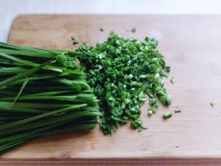 2、鳞虾木耳韭菜盒子,韭菜洗干净后淋干水份，切碎，放入容器中，首先加入少量食用油，搅拌均匀。这样韭菜不会出水哦。