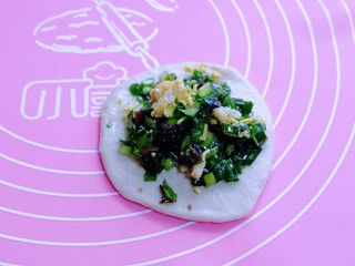 9、鳞虾木耳韭菜盒子,取一小块面团用擀面杖擀圆饼，包上拌好的馅儿。