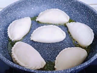 12、鳞虾木耳韭菜盒子,不粘锅中加入适量油，将包好的韭菜盒子放入锅中并间隔距离。