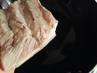 9、扣肉,锅倒入适量油（油要稍多些），烧至轻微冒烟放入五花肉，迅速盖好锅盖（动作一定要快，一定要快，快，快），不然油就四处飞溅啦（这一步稍微有点恐怖，但是自己保持淡定，不要慌，越慌就越乱）。