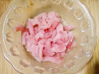 2、皮蛋瘦肉粥,猪里脊肉切丝，加1勺料酒和少量的盐抓拌均匀，腌制10分钟。