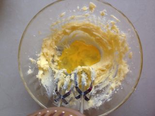 4、紫薯一口酥,用电动打蛋器先搅拌一下，再开启电源打发至颜色变浅，蓬松的状。分三次加入蛋液，每加入一次拌匀待吸收后，再加入下一次的蛋液