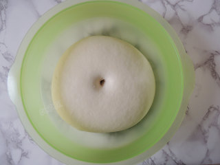 6、卡通小猪馒头,手指蘸少许面粉戳入面团中,拿出手指以后,面团不塌陷也不回缩就表示发酵完成了。将发酵好的面团取出。