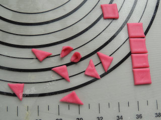 13、卡通小猪馒头,剩下的面片先切出正方形,然后斜切成三角形,窝起来做成猪的耳朵。一共二十个小耳朵。