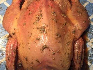 8、新年烤鸡,用酱汁再把鸡内外涂均匀，往鸡屁股里塞半个洋葱，保鲜膜包裹放冰箱腌一夜。（用剩的酱汁留着备用）