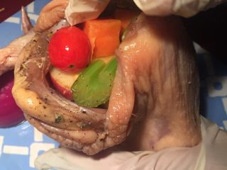 14、新年烤鸡,把鸡屁股竖起来往鸡肚子塞满各色配菜，最后塞半个洋葱，用两根牙签把鸡屁股缝起来。两只鸡腿末端用锡纸包裹住再用绳子把两只鸡腿绑在一起。