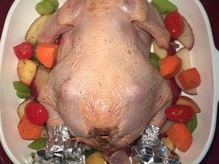 15、新年烤鸡,剩下的配菜铺在烤盘里，把鸡放在烤盘中间。