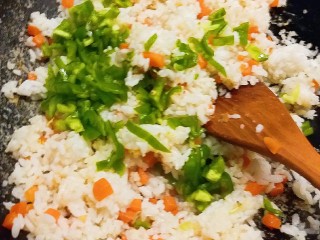 8、玉米粒番茄盅,边炒边将米饭疙瘩打散  放入葱碎和青椒丁 继续翻炒