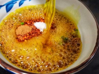 9、营养早餐【干拌红油抄手】,碗里放辣椒面、熟芝麻、豆鼓、盐、葱花、将一半的菜籽油分次浇在辣椒碗里，用筷子快速搅匀。