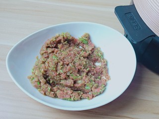 7、猪肉芹菜蒸饺,用筷子顺着一个方向搅拌上浆。