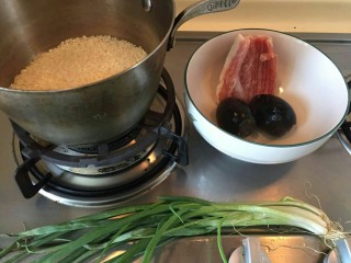 1、香滑皮蛋培根粥,准备一罐头米。一小段培根，两个皮蛋和一把香葱。