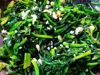 8、蒜蓉菠菜,放入盐和味精调味均匀撒上蒜粒翻炒几下即可出锅享用