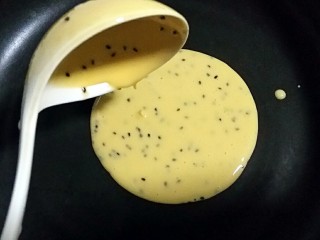 10、芝香蛋卷,取一个不沾平底锅,先舀一勺粉糊倒入锅中。