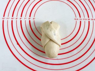 13、牛奶炼乳蔓越莓软欧,然后将左边的那条继续往面团右下方折，在底部将接口处捏紧。