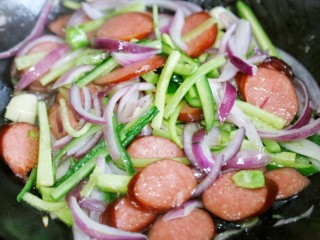 7、好吃到爆的火腿意面,再加入洋葱、黄瓜迅速翻炒。