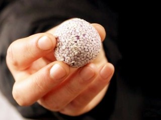 12、紫薯糯米丸子,用手把丸子握一握。使芝麻紧贴在丸子表面。
