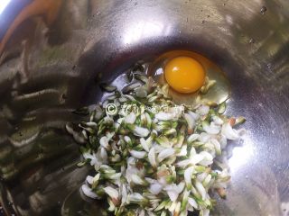 4、槐花饼,槐花倒入容器中，再磕入一个鸡蛋。