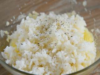 5、迷你土豆饼—又香又糯的小点心，加个餐很不错哦,倒入米饭，撒上黑胡椒，搅拌均匀。