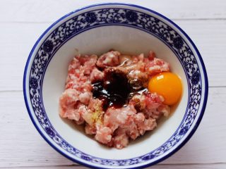 2、大葱猪肉发面包,猪肉馅放入一个大一点的容器里,加入花椒粉和鸡精,适量的盐和料酒,再加上老抽和生抽,最后再加入蚝油,打入一枚鸡蛋。