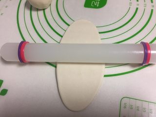 13、酥皮点心紫薯酥,收口的地方朝上,用擀面杖擀成牛舌状。