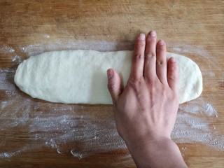 8、霜糖油条,用手将圆柱按扁，厚度大概在0.5-0.7厘米。