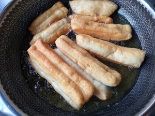 14、霜糖油条,炸的过程中用筷子不断的翻动，让油条可以受热均匀。