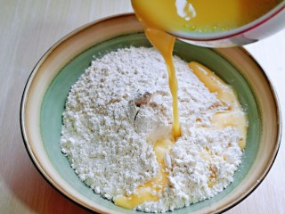 5、迷你小油条,将蛋液水分次加入面粉中。