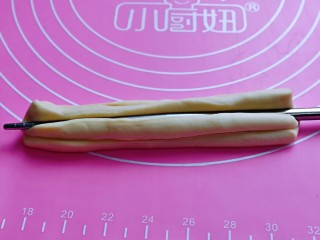 11、迷你小油条,两条面的两端捏在一起，用一根筷子放在条状面团的中间，压出印记，压的稍稍深一点！压好一面再反过来压痕迹！（两面都要用筷子压出印记）