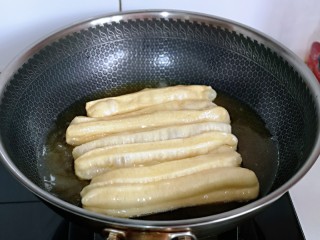 12、迷你小油条,锅中加入食用油，待油温7.8成热时，将油条胚放入油锅中 （有些人总问如何判断油温！很简单，可以用一小块面测试，面团放入锅中，立刻漂浮上来，油温即可）