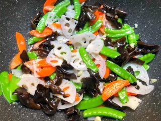 8、荷塘小炒,倒入焯好的荷兰豆,胡萝卜,藕片翻炒均匀,加入适量盐和适量蚝油翻炒至入味。