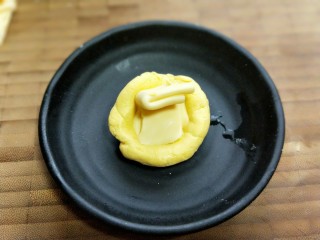 9、爆汁芝士南瓜球,取一块小面团，方手心儿压扁，放芝士片。