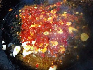 3、蒜蓉辣椒酱炒龙虾尾,放入自制蒜蓉辣椒酱、糖、料酒炒匀