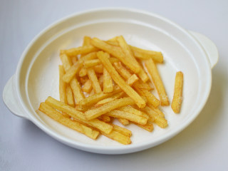 12、炸薯条,摆入碗中，撒入少许盐拌匀