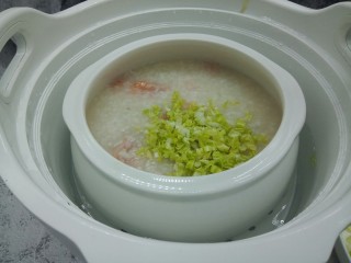 9、鲜虾砂锅粥,用筷子搅拌白菜丝。