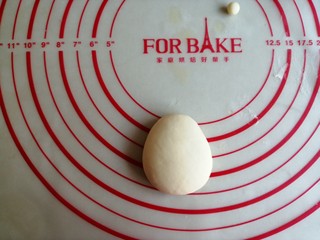 5、圣诞老人馒头,将白色小面团压扁一下，弄成上面小，下面宽一点