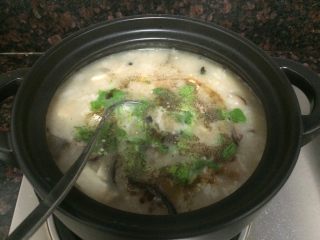 18、小米海鲜营养粥,撒上芹叶碎、胡椒粉，勺子拌匀。