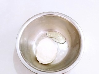 3、早餐油条,放入花生油，在略微揉面团，揉至花生油吸收进面团，油不用完全吸收，面盆里略留一些油。