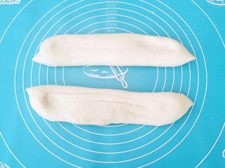 6、早餐油条,面团取出轻微按扁排气，不要揉面，用刀对半切开。