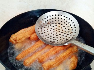 13、早餐油条,油温重新升高后，放入油条在复炸一次，复炸是为了逼出多余的油脂，油条也会更酥脆。