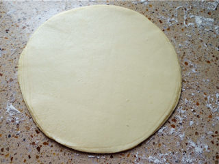 11、春饼,8张面皮全部叠在一起,然后用手轻轻按一下,两面都按,这样一会好擀一些,而且两面轻轻按压也可以调整饼大小均匀度.