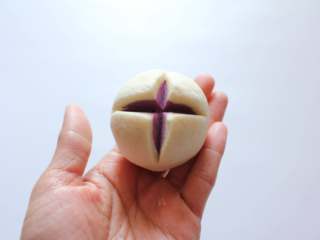 14、开花紫薯馒头,用一把锋利的刀在顶部切十字口！切好以后可以用手在面团四周团一下，整理成蛋的形状的样子。