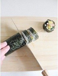 13、紫菜包饭,卷好的紫菜卷,用刀切成约1.5-2cm厚。装盘即可