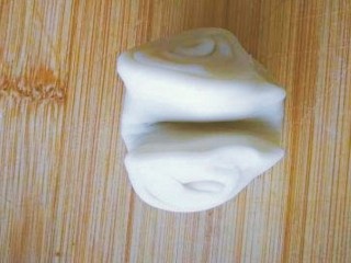 16、玫瑰鲜花饼,取一个卷，用手指在中间按压一下，将两头向中间捏拢