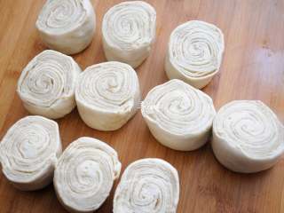 14、老字号甜咸味椒盐油酥金丝饼,上一步的面卷用锋利的刀片拦腰切开,漂亮的截面就有了,每个烧饼胚大约80克。